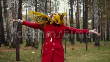迷人的年轻女子抛出黄色的叶子脱落。 穿着<strong>风衣</strong>在秋天公园散步的女孩。 慢动作